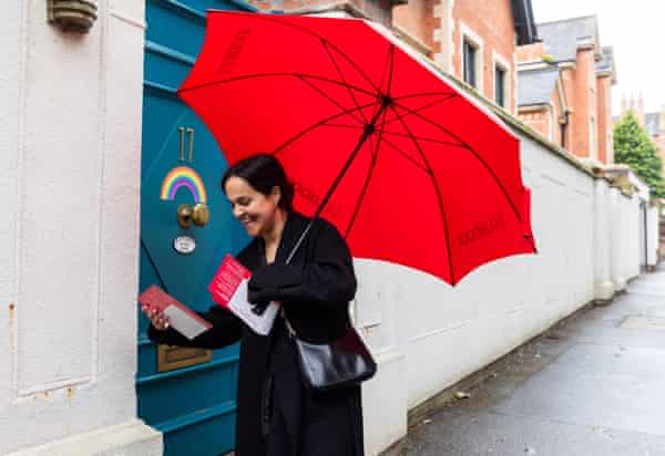 Whittome, holding a bright red umbrella, knocking on a door