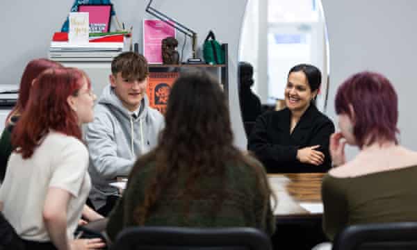 Nadia Whittome sits at a table with young people